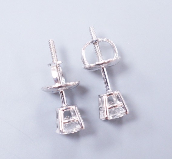 A pair of 18k white metal and solitaire diamond set ear studs, gross weight 0.9 grams